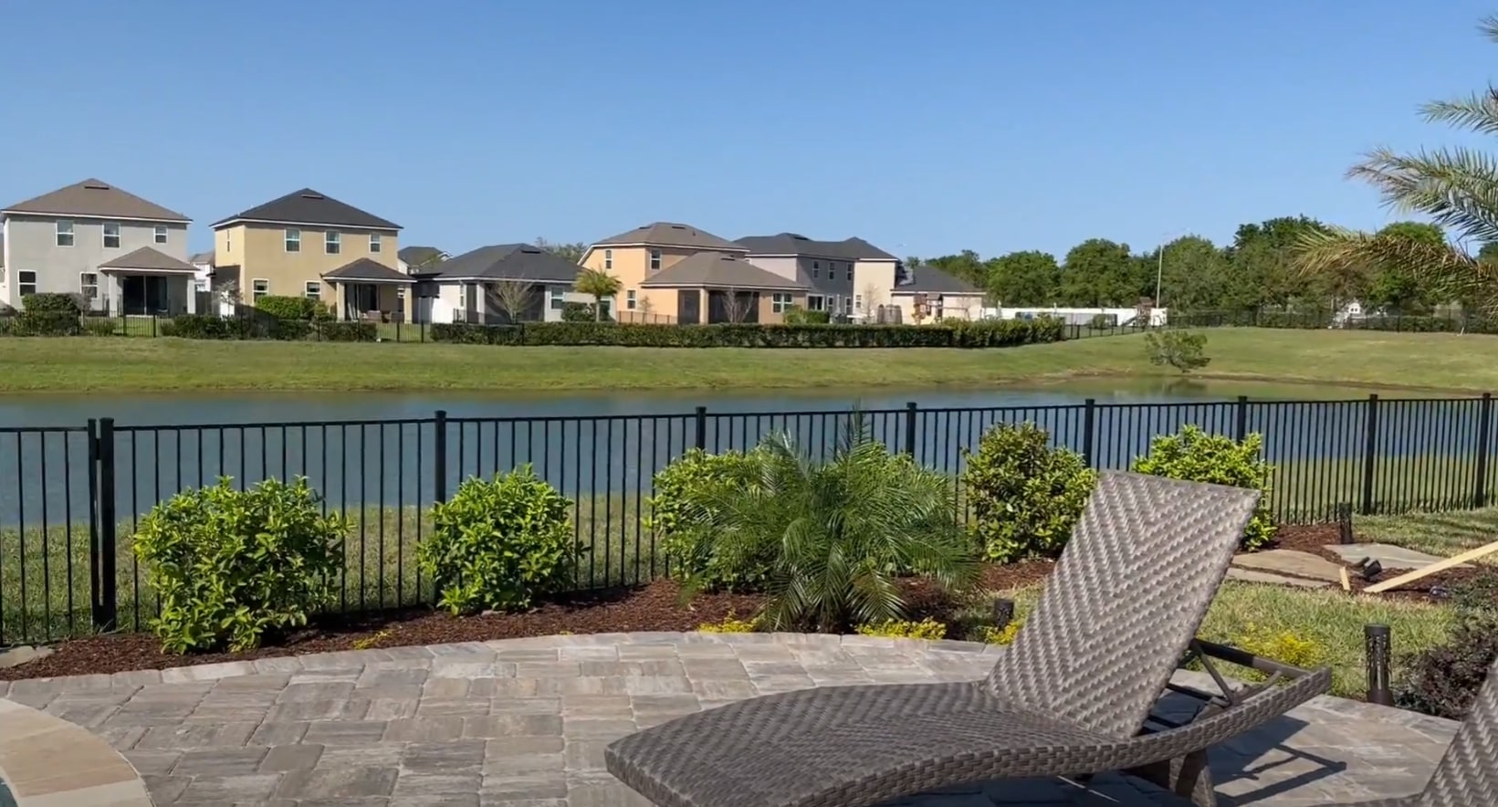 Waterfront Landscape Design Waterfront landscape with professional outdoor living space, patio furniture, and strategic plant placement