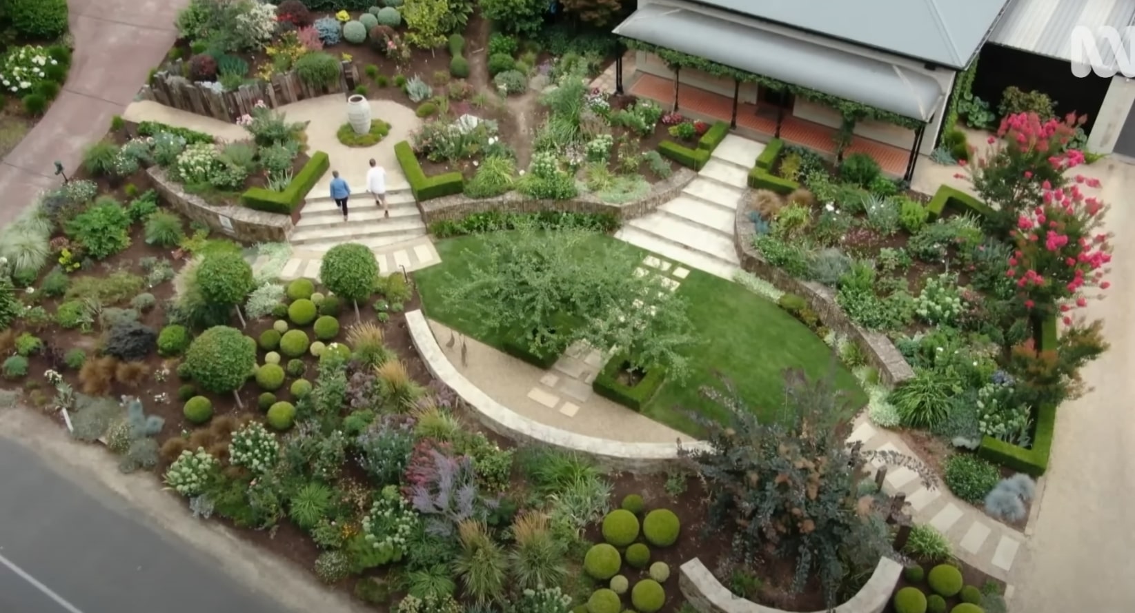 Artistic Garden Design Aerial view of stunning garden design with geometric lawn patterns, ornamental spheres, and diverse plant selections