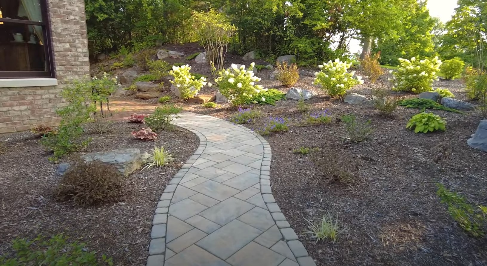Hardscape and Walkway Design Elegant curved walkway with professional hardscaping, stone pathways, and drought-resistant plantings