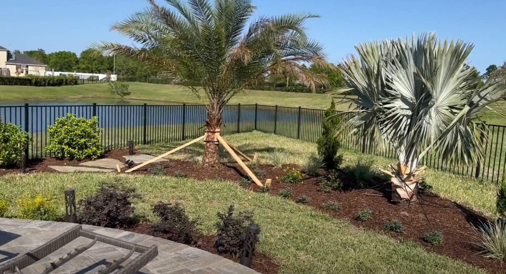 Professional Landscape Design - RightTouch DeSoto Landscaping Beautiful landscaped backyard with tropical plants, palm trees, and professional hardscaping in DeSoto, TX